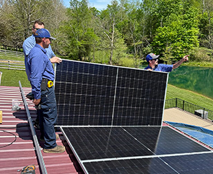 Technicians working on Solar panels on a roof.